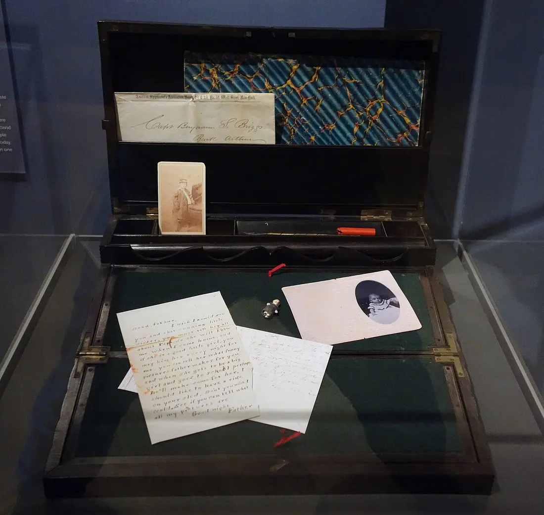 Écritoire ouverte dans une vitrine, avec des lettres et des photographies